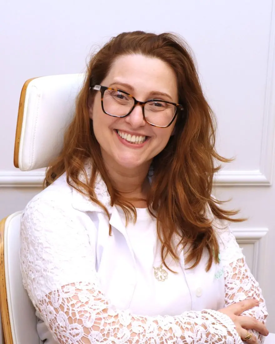 Dra. Cintia Urel sorrindo em seu consultório
